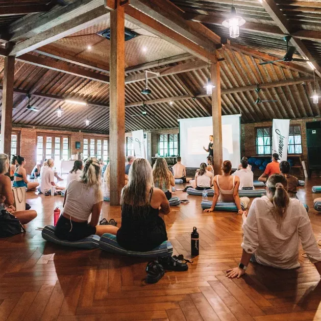 A serene yoga teacher guiding students in a sunlit studio, symbolizing the best online yoga teacher training programs for 2025